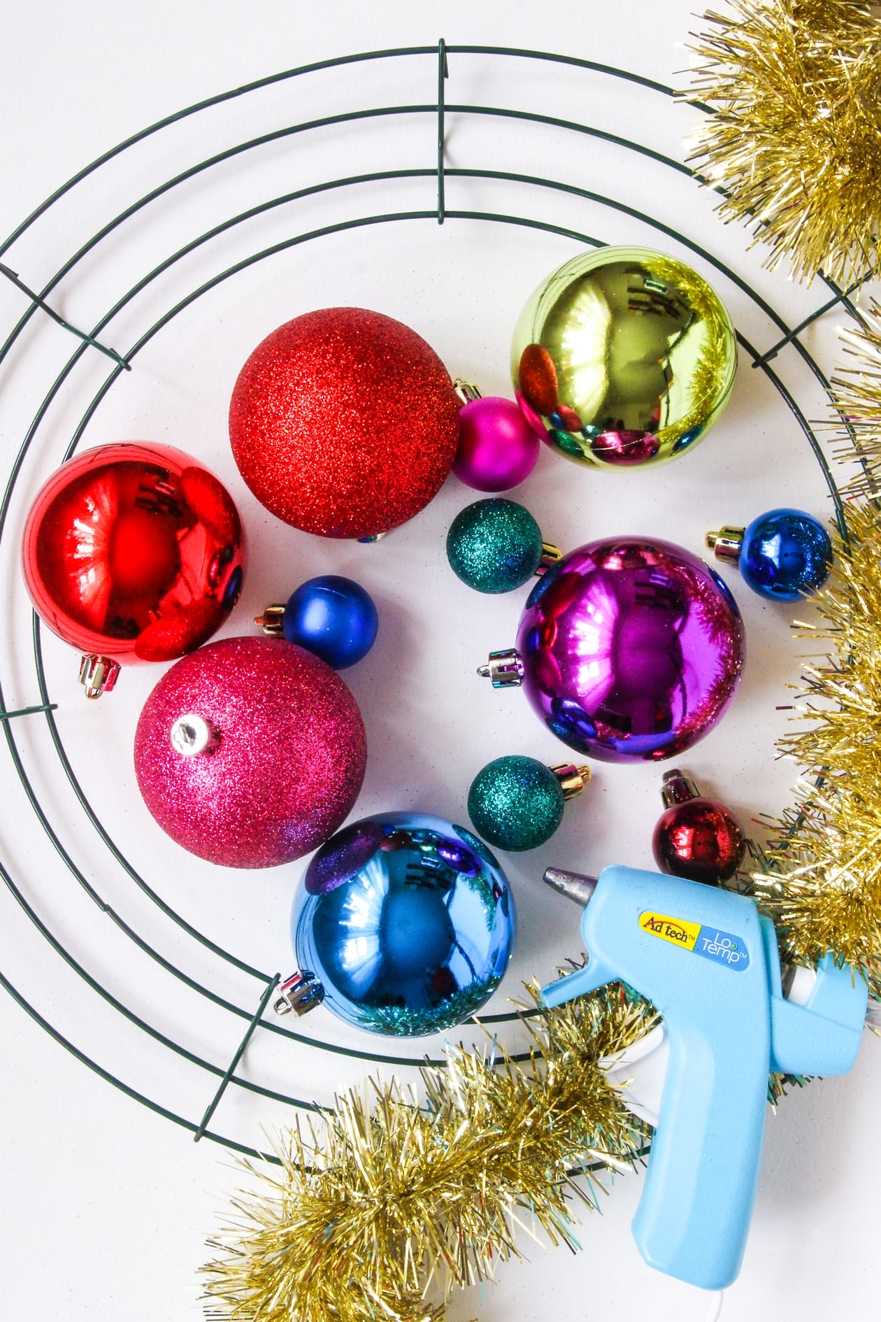 diy-Ornament-wreath-materials What you'll need to make an ornament wreath: wreath frame, ornaments, hot glue gun, tinsel, wreath frame